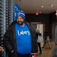 Alumni Director Mike Przydzial chatting with two others at merch table